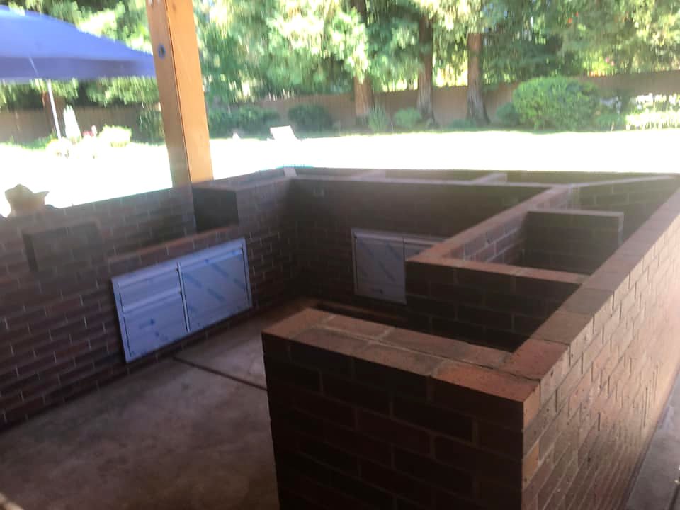 L-shaped brick outdoor kitchen under construction by Warrens Masonry