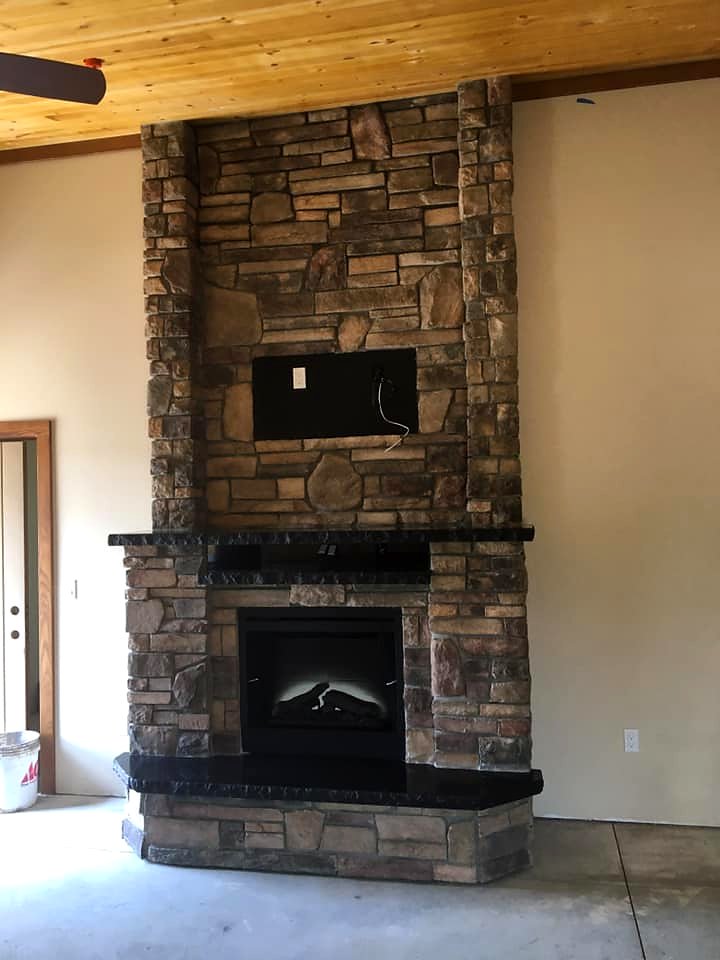 Ledger stone fireplace with wood plank ceiling by Warrens Masonry